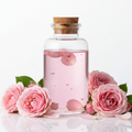 Agua de rosas para cosmetica en frasco de vidrio transparente con tapa de corcho y rosas color rosa en la parte de abajo